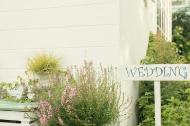Wedding Sign Near House With Green Plants